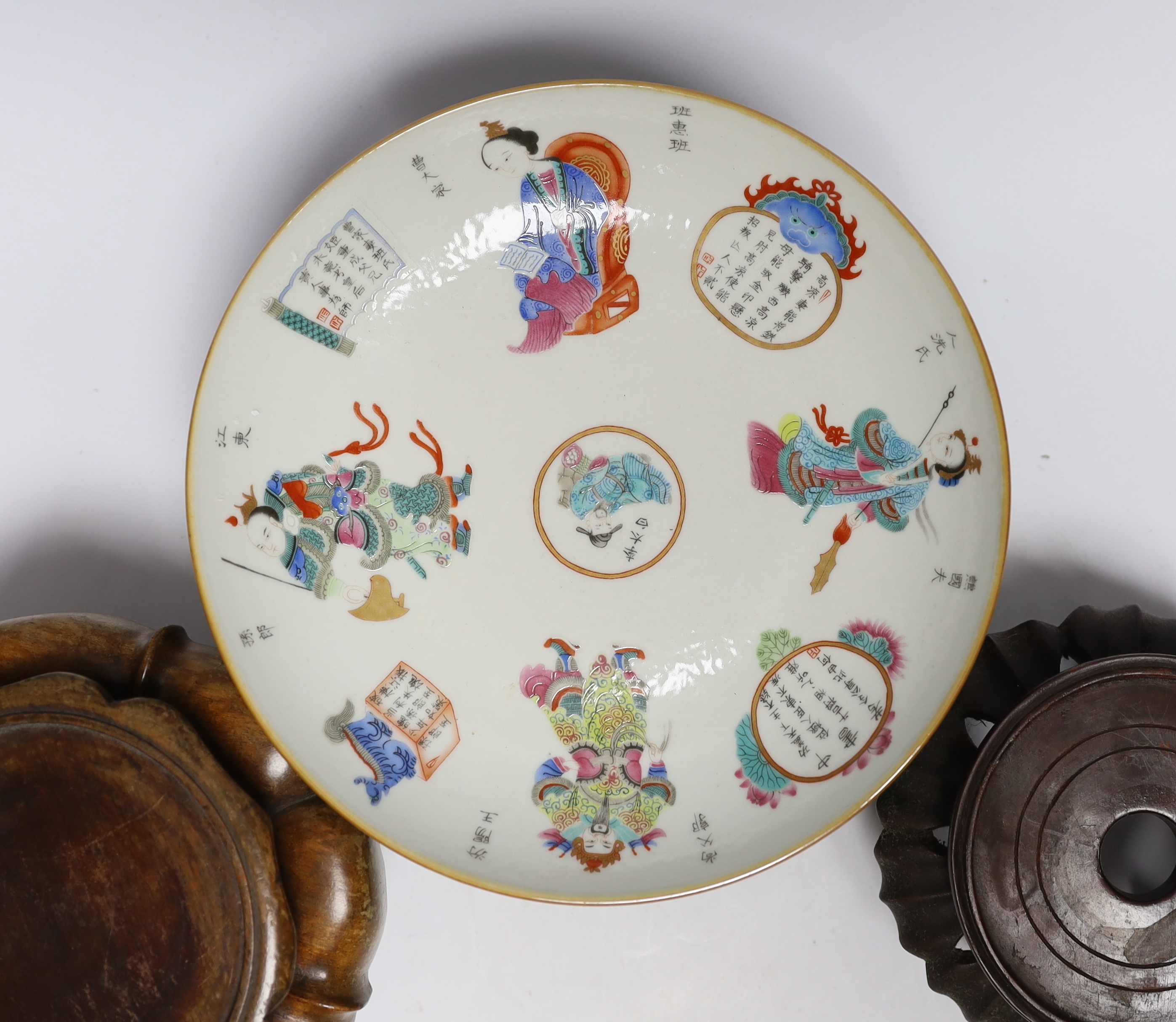 A Chinese famille rose dish and three carved hardwood stands, largest 23cm in diameter